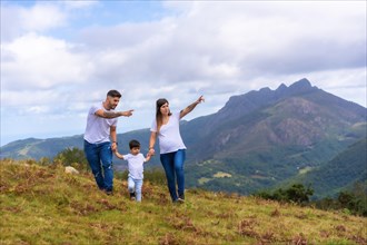 Horizontal photo with copy space of parents showing landscape to a little boy in the mountain