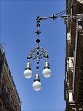Decorated street lamp in front of a blue sky