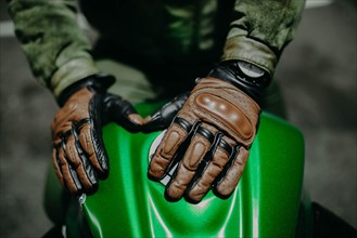 A motorcyclist shows his leather brown gloves for a touring trip to the camera