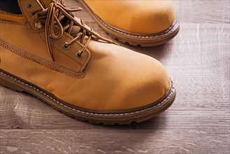 Very close view of a pair of work boots wooden board