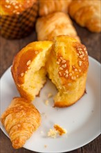 Fresh baked muffin and croissant mignon on old wood table