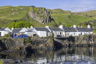 Row of white-harled workers cottages in former slate-mining village Ellenabeich on the isle of Seil