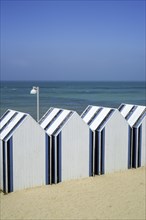 Row of decorated beach cabins at seaside resort Yport along the North Sea coast