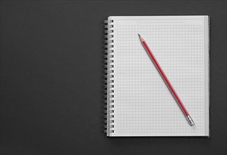 Clean square copybook with red pen on black background education concept