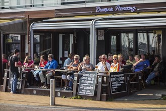 Tourists sitting in a pavement cafe with a beer in seaside resort Blankenberge along the Belgian North Sea coast