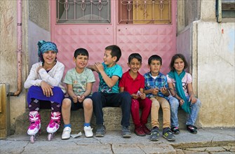 Turkish children sitting on doorstep of house in the city Erzurum
