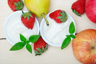 Fresh fruits and whole milk yogurt on a rustic wood table