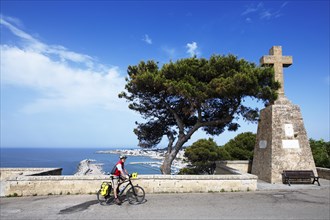 Cyclist enjoying the view of the harbour from the Sanctuary of San Marina de Leuca