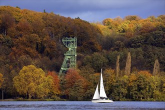 A sailing boat in autumn with the foerdegeruest of the Carl Funke colliery