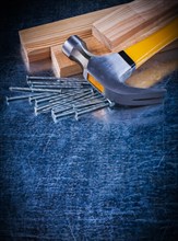 Copy room image of construction nails hammer and wooden bricks on scratched metallic surface maintenance concept