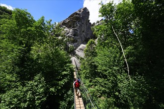 Hikers on the suspension bridge on the Percorso delle sette pietri