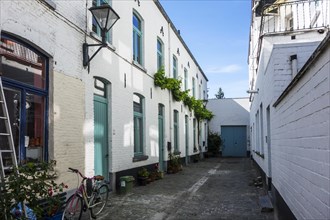 Old dead-end alley with white working-class houses in the city Aalst
