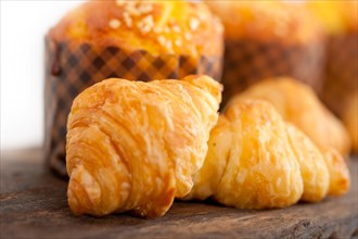 Fresh baked muffin and croissant mignon on old wood table