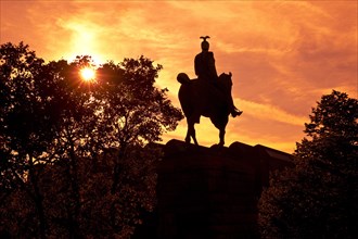 Equestrian statue of Kaiser Wilhelm II backlit at sunset