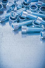 Group of threaded nuts and bolts on metallic background copy space image maintenance concept
