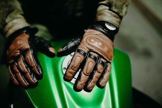 A motorcyclist shows his leather brown gloves for a touring trip to the camera