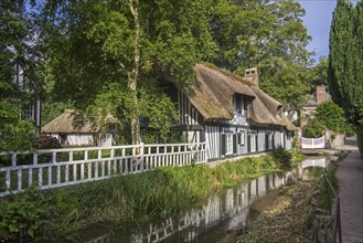 Timber-framed house with thatched roof along the river Veules