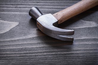 Claw hammer on vintage wooden board Close-up construction concept