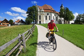 Cyclist with touring bike in front of the Wieskirche