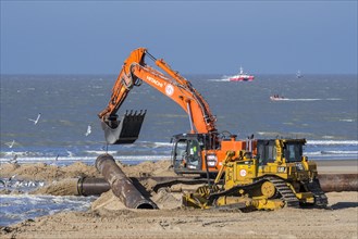Bulldozer and hydraulic excavator installing pipeline during sand replenishment