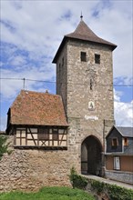Town gate and colorful facades of timber framed houses at Dambach-la-Ville