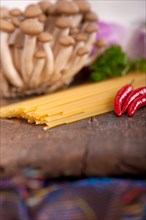 Italian pasta and mushroom sauce raw ingredients over rustic old wood