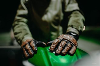 A motoA motorcyclist shows his leather brown gloves for a touring trip to the camera