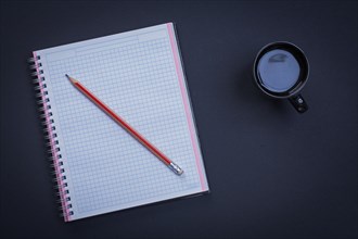 Clean square workbook pencil and cup of coffee on black background office concept