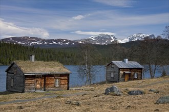 Log cabin with sod roof along lake at Fatmomakke