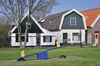 Seesaw and traditional houses in the village Oudeschild