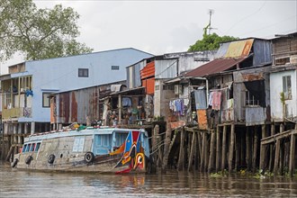 Stilt houses and traditional Vietnamese wooden boat in the Mekong Delta near Can Tho