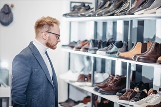 Business successful man businessman chooses shoes for himself in a shoe store