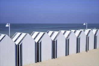 Row of decorated beach cabins at seaside resort Yport along the North Sea coast