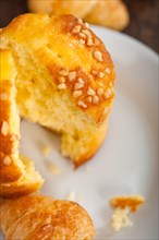 Fresh baked muffin and croissant mignon on old wood table