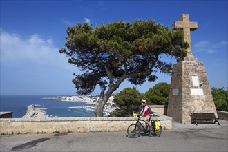 Cyclist enjoying the view of the harbour from the Sanctuary of San Marina de Leuca