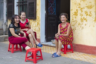 Vietnamese women sitting and chatting in front of their house in the city Ninh Binh in the Red River Delta of northern Vietnam