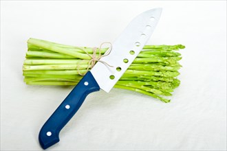 Fresh asparagus from the garden over white background with kitchen knife