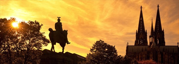 Equestrian statue of Kaiser Wilhelm II backlit with the silhouette of the cathedral