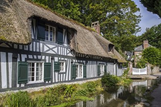 Timber-framed house with thatched roof along the river Veules