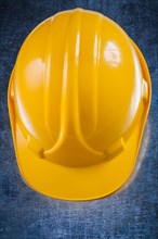 Yellow protective building helmet on scratched vintage metallic background close up version construction concept