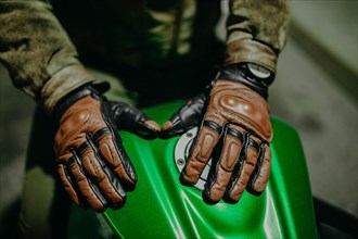 A motorcyclist shows his leather brown gloves for a touring trip to the camera
