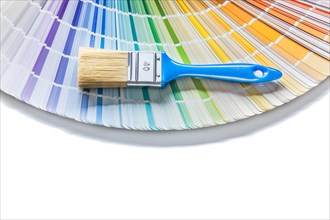 Blue paint brush onopened pantone color palette guide isolated