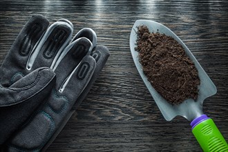 Gardening hand spade soil safety gloves on wooden board