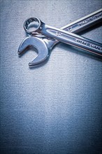 Stainless steel flat spanner and hook spanner on a metallic background Design concept