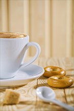 Composition of white coffee cup with spoon and bread gate