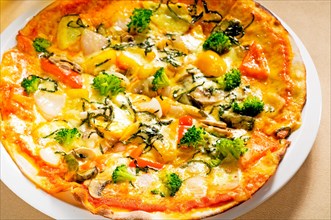 Fresh italian thin style vegetarian pizza with fresh mixed vegetables close up