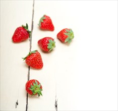 Fresh organic strawberry over white rustic wood table