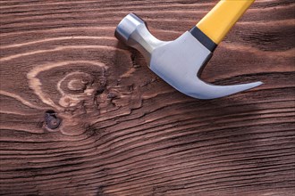 Metal claw hammer on brown vintage wooden board construction concept