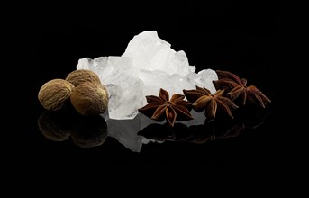 Crystal sugar and spice over black reflective surface background