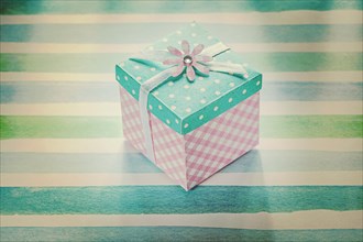Wrapped present box on blue striped fabric holidays concept